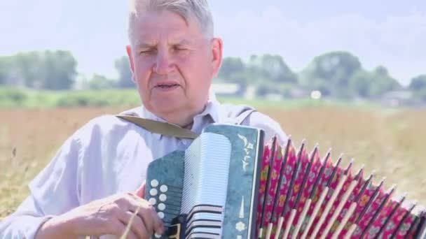 El abuelo toca el acordeón. — Vídeo de stock