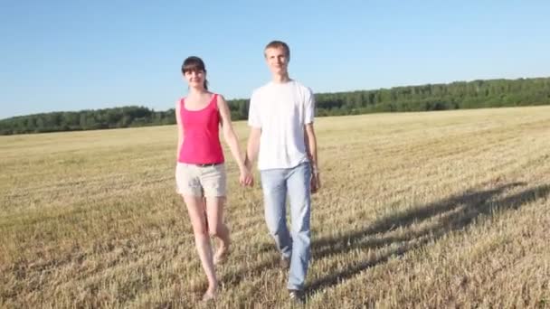 Guy and girl go in field — Stock Video