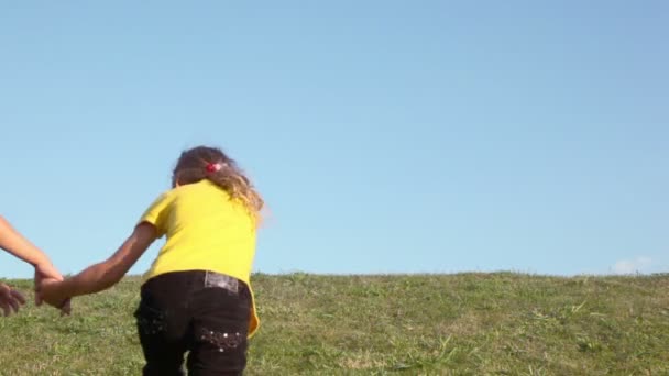 Jongen met meisje lopen weg door gras hill — Stockvideo