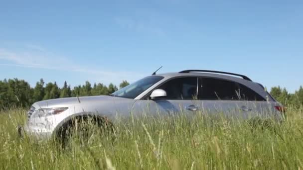 Zilverkleurige jeep in veld — Stockvideo