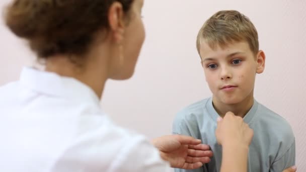 Woman doctor takes thermometer from boy — Stock Video