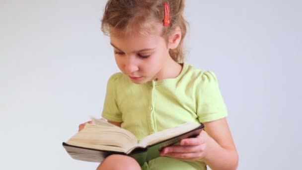 Pequeña niña lee libro — Vídeo de stock