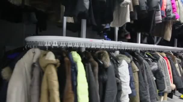 Many winter clothes hang at conveyor — Stock Video