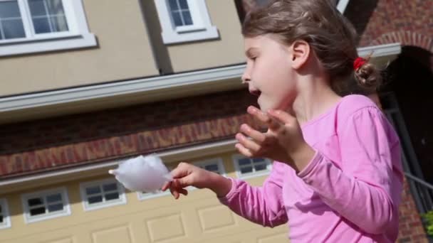 Маленька дівчинка їсть цукерки — стокове відео
