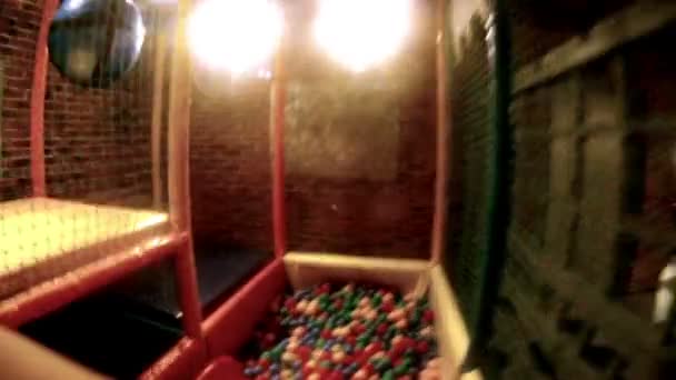 Enfant joue avec des boules de couleur dans la salle de jeu 