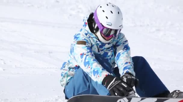 Snowboarder sits on snow — Stock Video