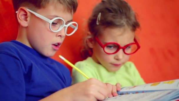 Crianças em óculos sentam-se juntas — Vídeo de Stock