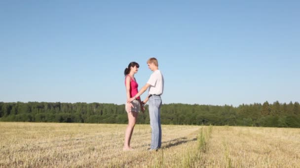 Girl stands with guy in field — Stock Video