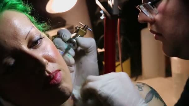 Художник делает татуировку для женщины — стоковое видео