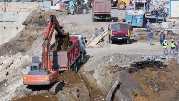 Excavadora y trabajadores en obra — Vídeo de stock