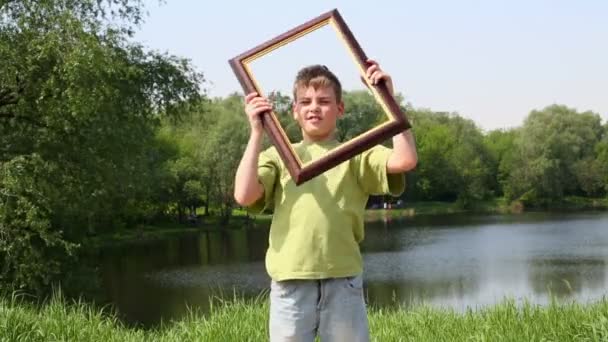 Young boy holds picture frame — Stock Video