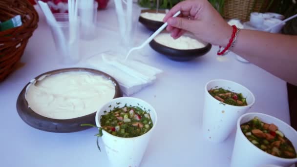 La main ajoute de la crème sucrée à okroshka — Video