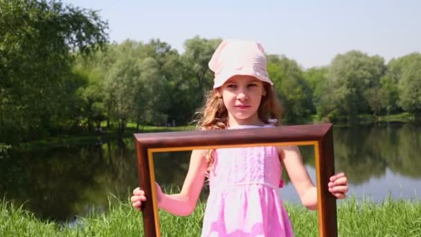 Little girl holds picture frame — Stock Video