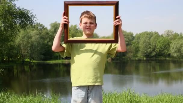 Young boy holds picture frame — Stock Video