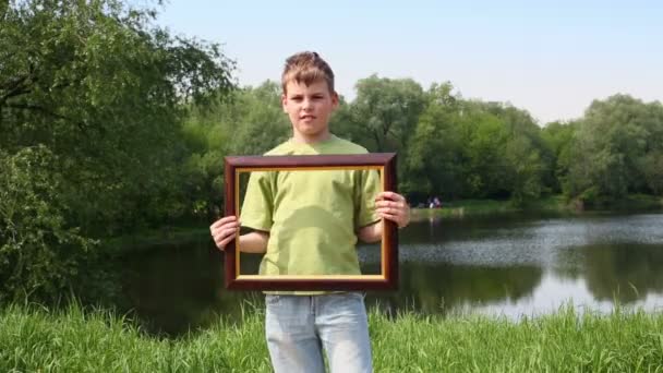 Young boy holds picture frame — Stock Video