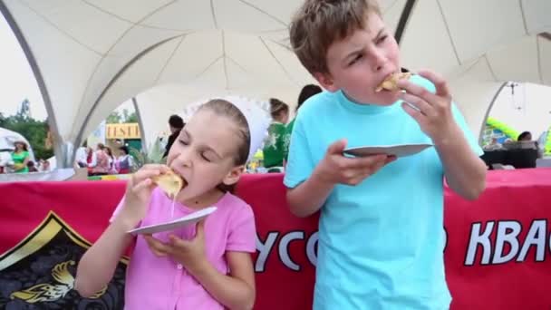 Děti jedí palačinky gastronomického festivalu — Stock video