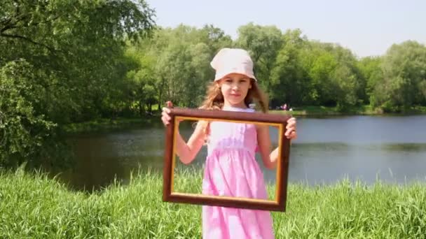 Mała dziewczynka posiada ramki na zdjęcia — Wideo stockowe