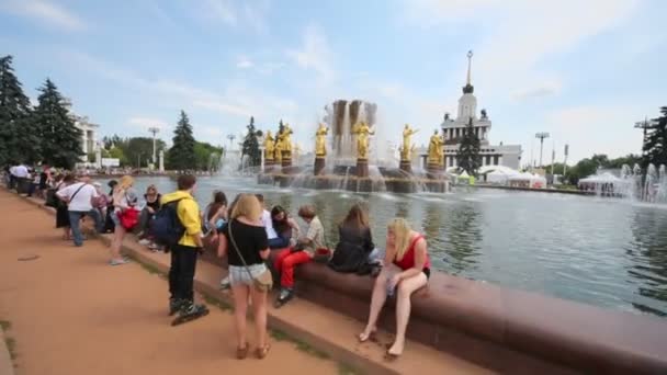 Lidé sedí na fontáně přátelství lidí — Stock video