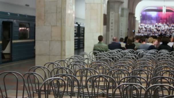 Mensen kijken koor zingen in de metro — Stockvideo