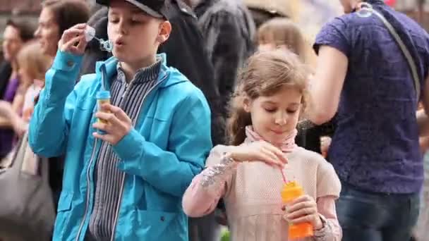 Дети накачивают мыльные пузыри — стоковое видео