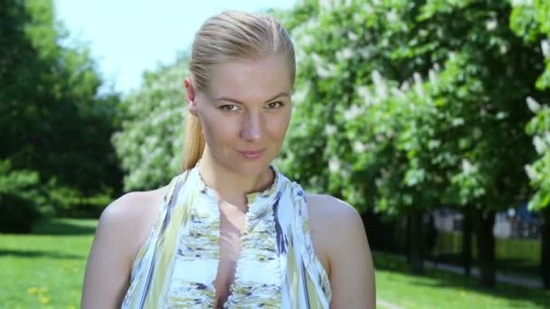 Young woman smiles in park — Stock Video