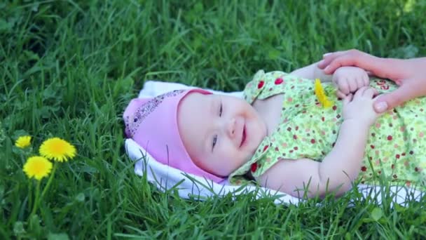 Baby girl lies and hold dandelion — Stock Video