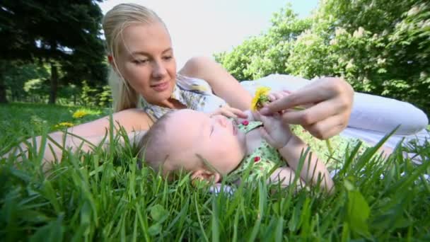 Moeder ligt in de buurt van haar baby dochter — Stockvideo