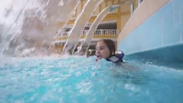 幸せな女の子がプールで泳ぐ — ストック動画