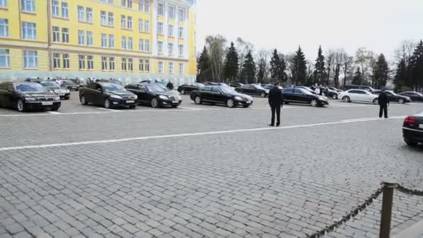 Полицейские идут рядом с правительственными автомобилями — стоковое видео