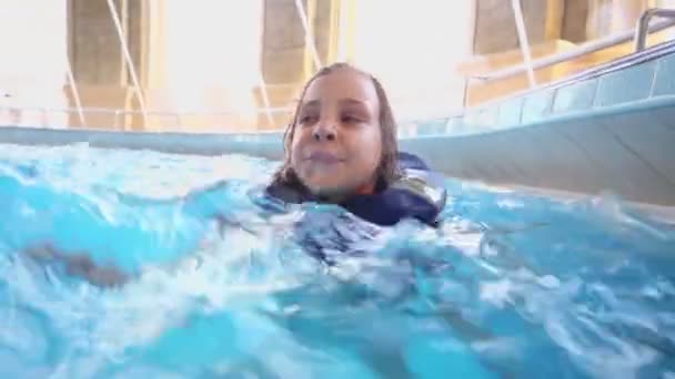小さな女の子がプールで泳ぐ — ストック動画