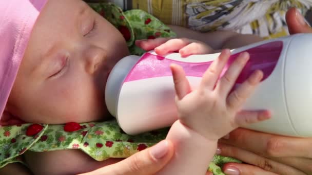 Little baby sucks milk from bottle — Stock Video