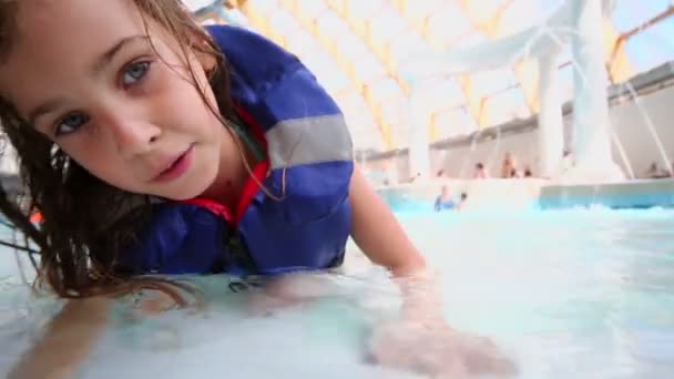 Niña se encuentra en la piscina — Vídeo de stock