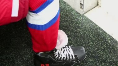 Hokey oyuncusu üniformalı bankta oturur