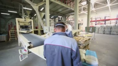 İki adam konveyör üzerinde çalışmak