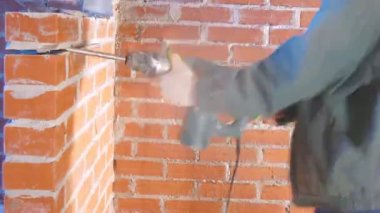 İki işçi tuğla duvardan kaldırma