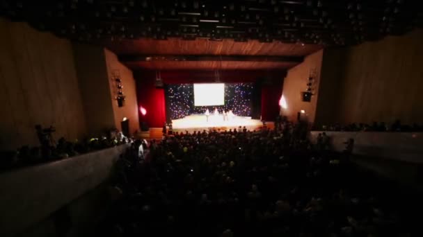 Toeschouwers zitten in donkere hal van theater — Stockvideo