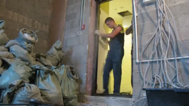 Young workers putting new door — Stock Video