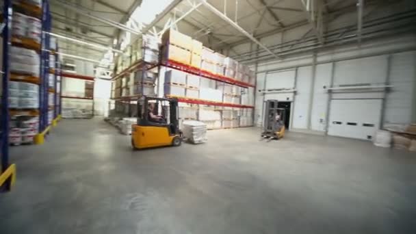 Man rides on loader in warehouse — Stock Video