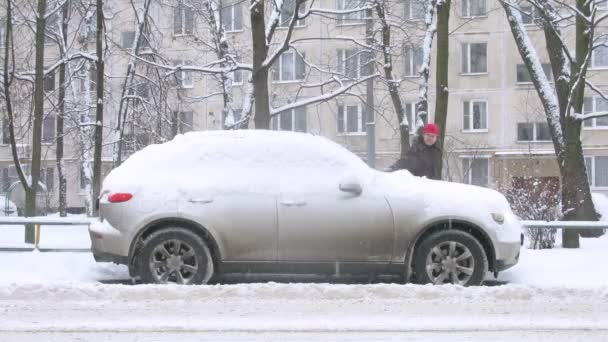 Hombre quitar la nieve del coche — Vídeo de stock