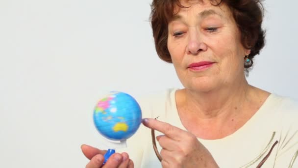 年配の女性は地球のミニチュアを保持します。 — ストック動画