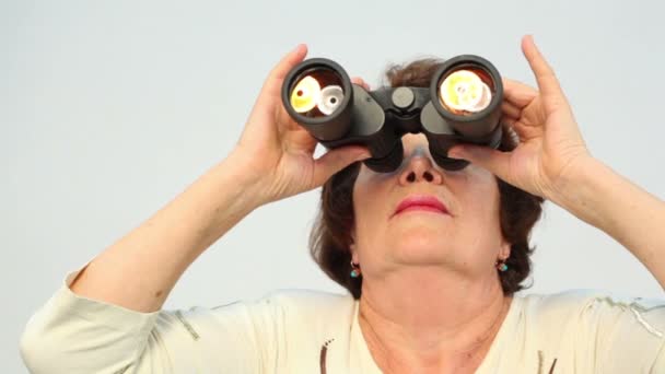 Mulher velha olha em binóculos — Vídeo de Stock