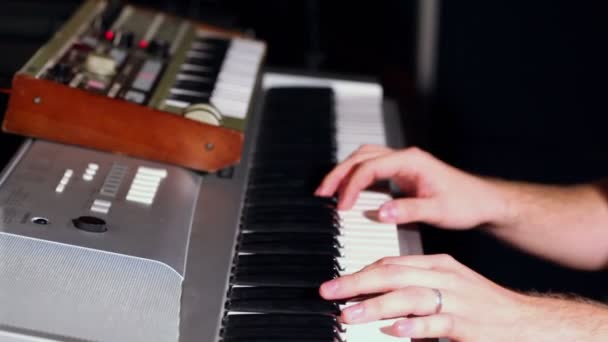 Mann spielt Synthesizer im dunklen Studio — Stockvideo