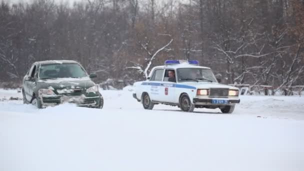 Carro da polícia monta perto de veículo na neve — Vídeo de Stock