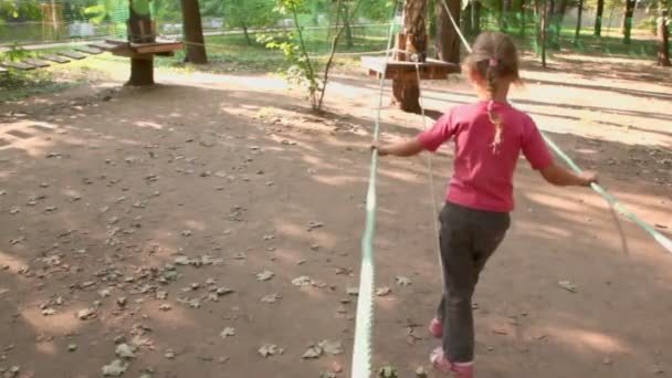 Kleines Mädchen läuft auf Spielplatz am Seil — Stockvideo