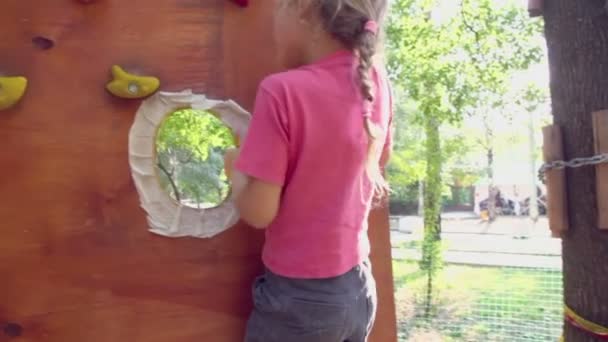 Niña clambers en la pared colgante — Vídeos de Stock