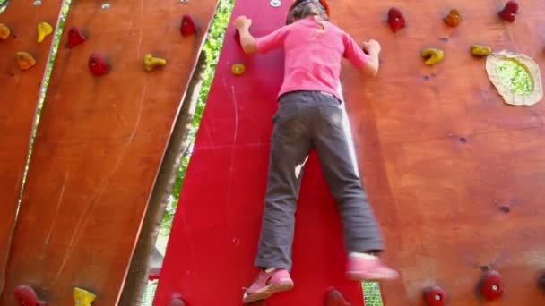 Маленька дівчинка повзе на підвісну стіну — стокове відео