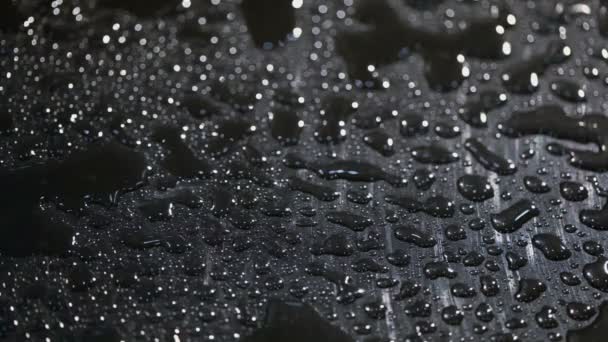 Spatters of water fall on dark surface — Stock Video