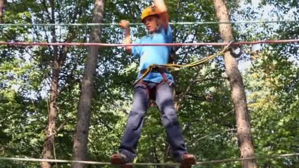 Мальчик в шлеме прогулки в альпинистском центре — стоковое видео