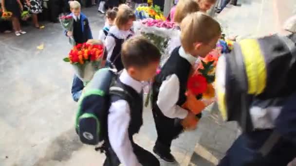 Kinderen met bloemen invoeren van school — Stockvideo