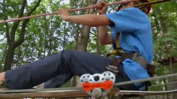 Garçon promenades sur pendentif planche en bois — Video